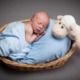 Newborn baby with a white sheep toy