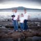 Family wearing white tops and Jeans at an Auckland beach with Rangitoto Island in the background