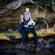 Family sitting on a tree stump at the beach