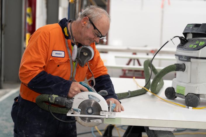 Commercial Photography Auckland Commercial staff photography for Fairfax New Zealand: Worker cutting a board